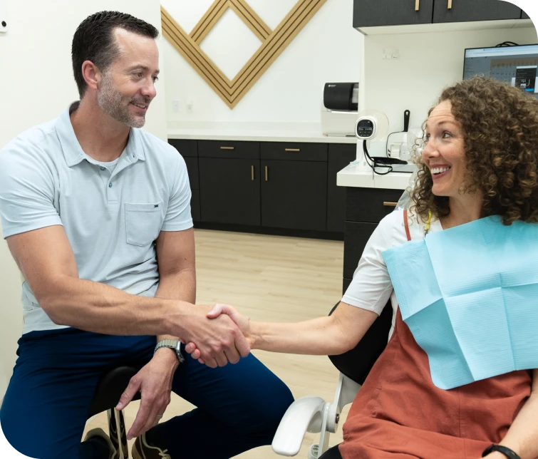 An Only Crowns dentist greeting a patient in the office